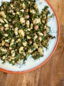 A mixed IQF bean salad served over a creamy yoghurt base, finished with fresh herbs.