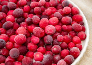 A plate full of bright red IQF frozen cranberries.