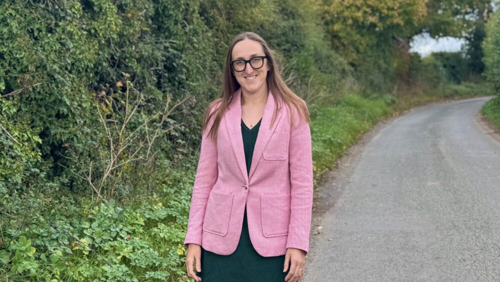 Kelly Jay, Place UK's head of finance, standing in Norfolk Country lane.
