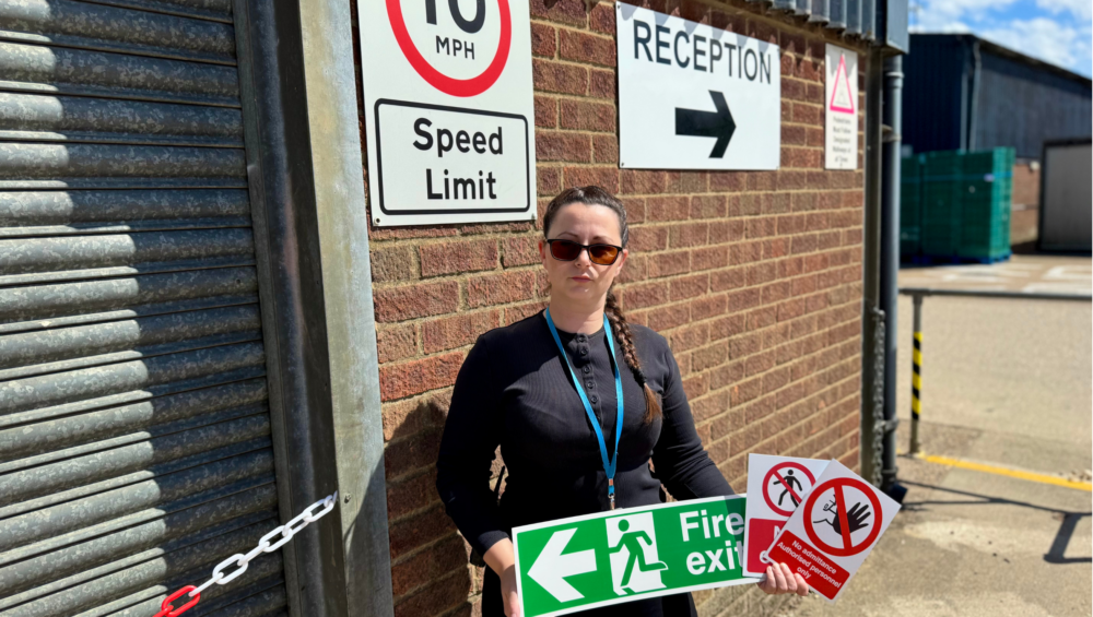 Place UK's Health and Safety Advisor Antoaneta holding signs on site.